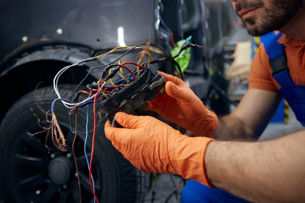 Mechanic shows the damaged vehicle wiring