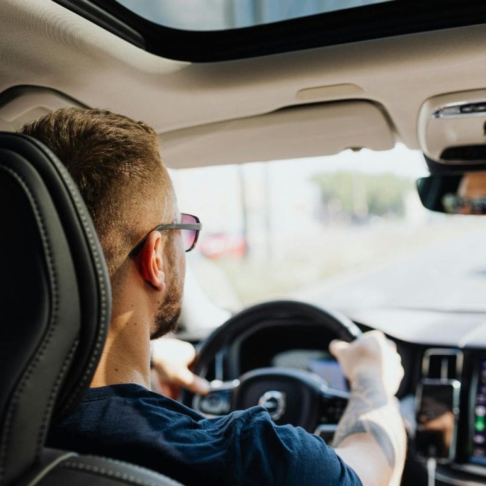 A man is driving his own car and focusing on the road